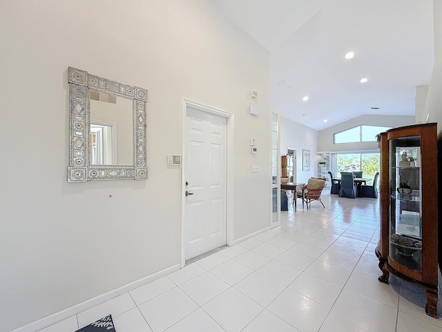 foyer featuring light tile patterned flooring and vaulted ceiling