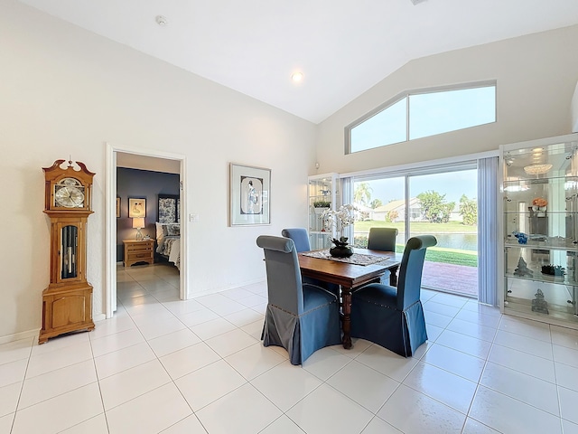 dining space featuring light tile patterned floors and vaulted ceiling