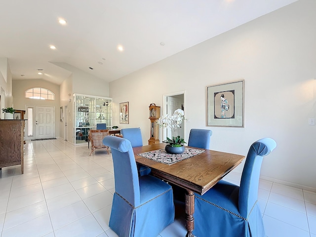 dining room featuring light tile patterned floors and vaulted ceiling