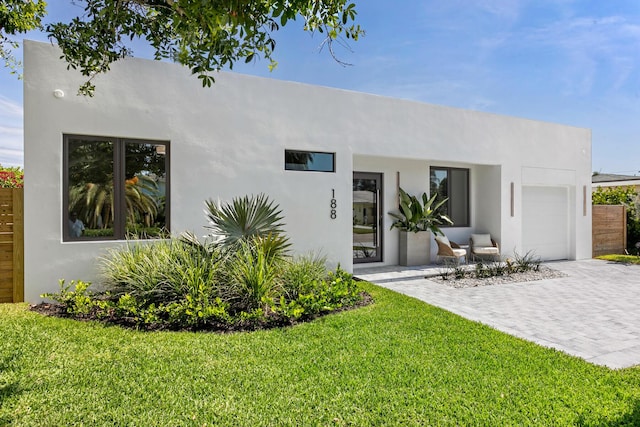 rear view of house featuring a lawn and a garage