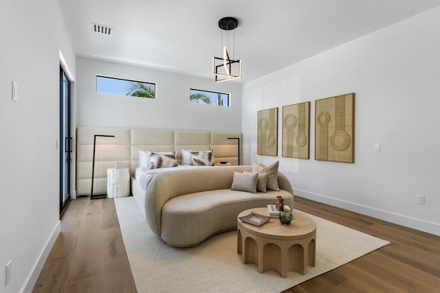 bedroom with hardwood / wood-style floors and a chandelier