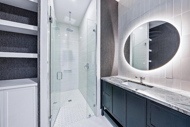 bathroom featuring vanity, an enclosed shower, and tile walls