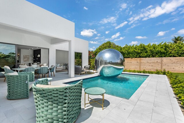 view of pool featuring outdoor lounge area and a patio