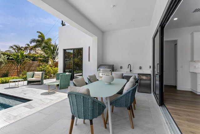 view of patio featuring an outdoor kitchen, a grill, and sink