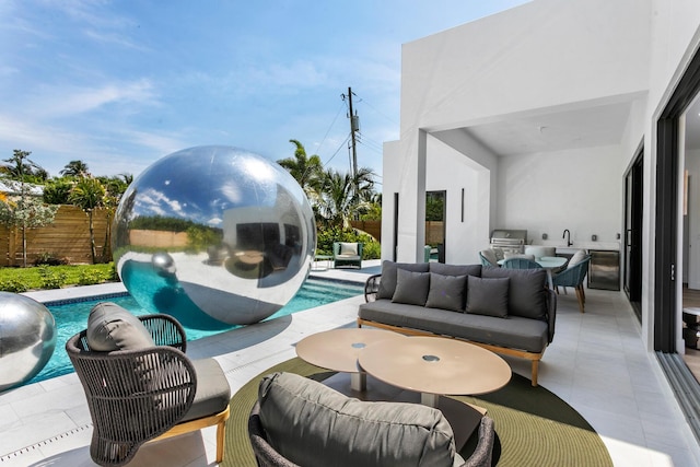 view of patio / terrace featuring a fenced in pool, area for grilling, an outdoor living space, and an outdoor kitchen