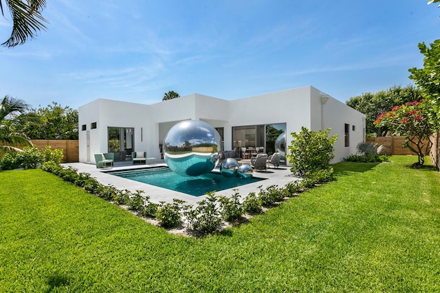 rear view of property with a lawn, a fenced in pool, an outdoor hangout area, and a patio