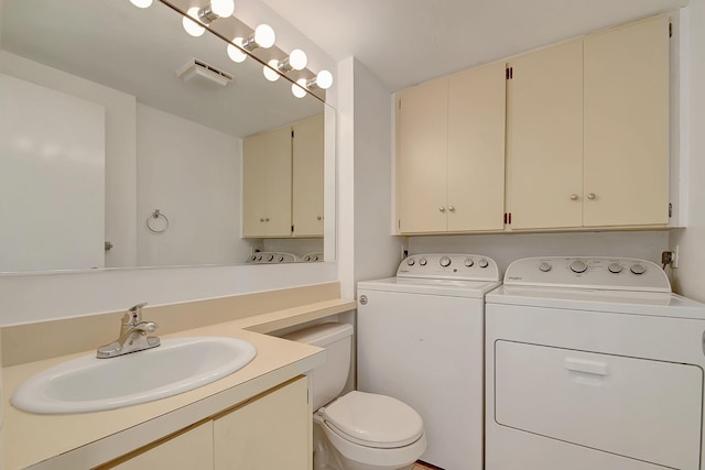 bathroom with washing machine and clothes dryer, vanity, and toilet