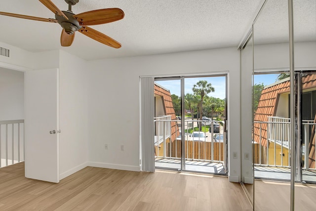 unfurnished room featuring french doors, ceiling fan, light hardwood / wood-style flooring, and a textured ceiling