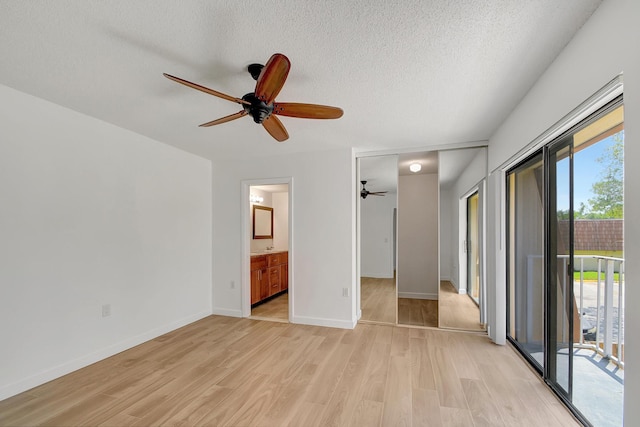 unfurnished bedroom featuring access to exterior, connected bathroom, light hardwood / wood-style floors, and multiple windows