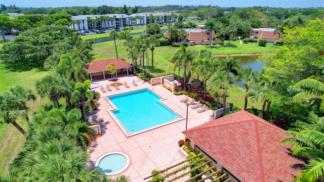 view of swimming pool featuring a water view, a yard, and a patio