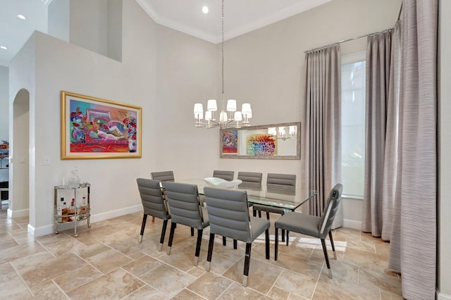 dining space featuring a high ceiling, crown molding, and a notable chandelier