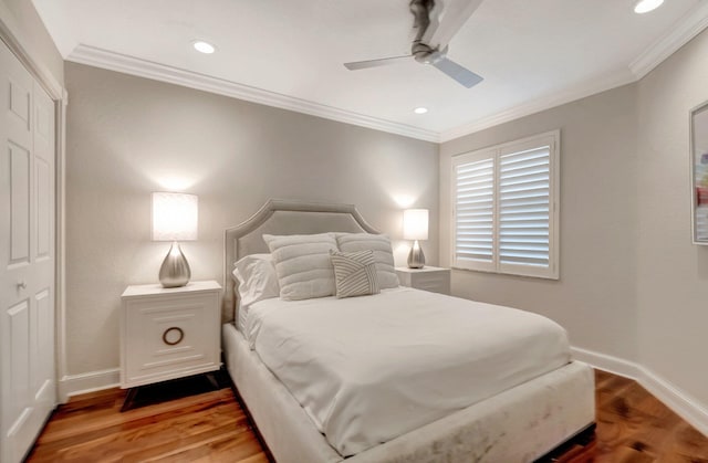 bedroom with hardwood / wood-style floors, ceiling fan, crown molding, and a closet