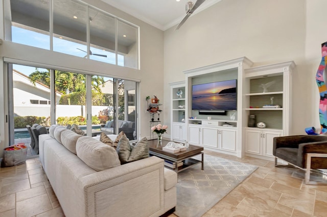 living room with built in shelves, a towering ceiling, and ceiling fan