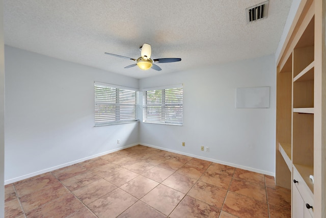 unfurnished room with ceiling fan, light tile patterned floors, and a textured ceiling