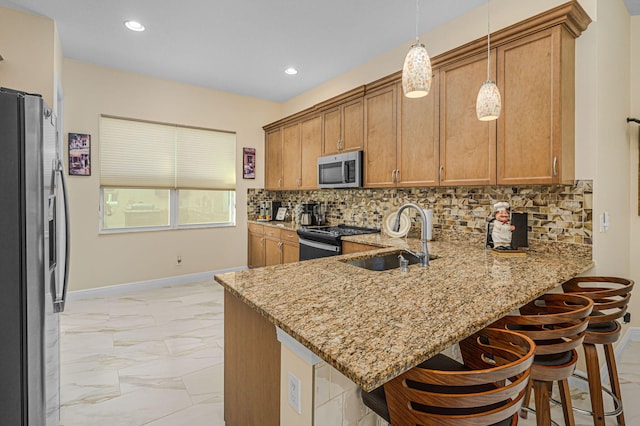 kitchen with stainless steel appliances, a kitchen bar, kitchen peninsula, and sink