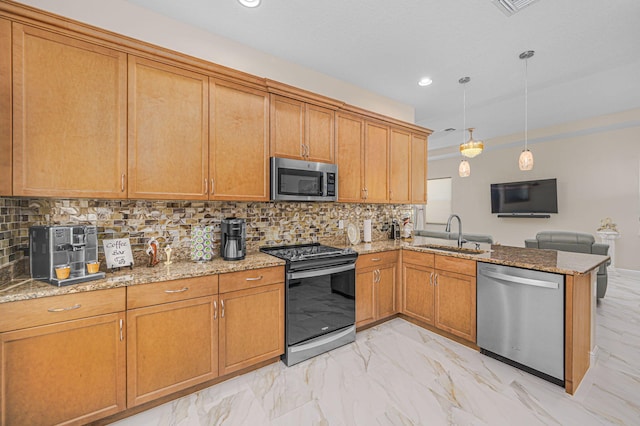 kitchen featuring kitchen peninsula, appliances with stainless steel finishes, decorative backsplash, hanging light fixtures, and sink