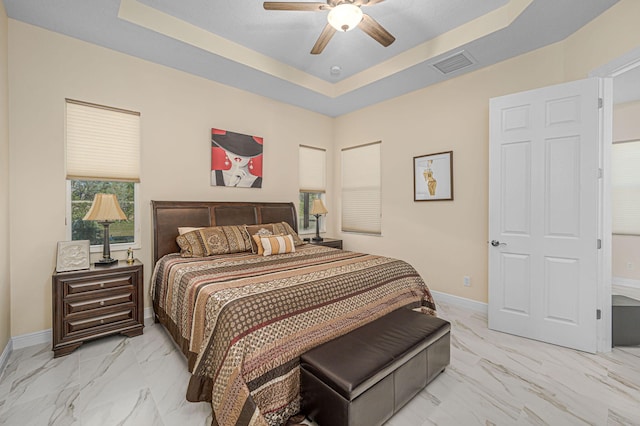 bedroom featuring ceiling fan and a raised ceiling