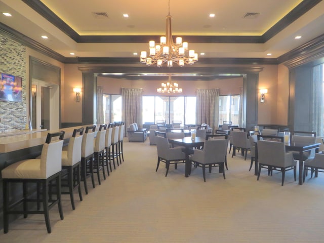 dining area with light carpet, crown molding, a raised ceiling, and a notable chandelier