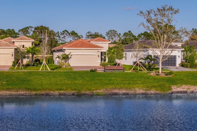 mediterranean / spanish house with a water view and a front lawn