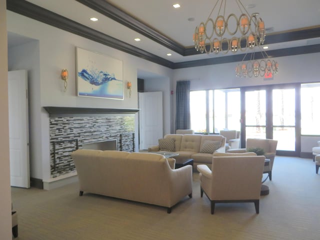 carpeted living room with a notable chandelier, crown molding, and a tray ceiling