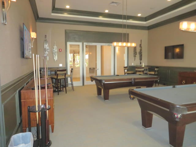 game room with pool table, a raised ceiling, carpet floors, french doors, and ornamental molding