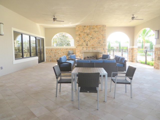 view of patio / terrace featuring ceiling fan and an outdoor living space with a fireplace