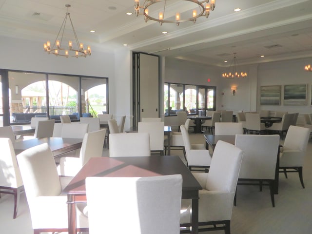 dining room featuring a wealth of natural light, crown molding, a towering ceiling, and a raised ceiling