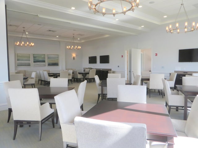 dining space with a tray ceiling and ornamental molding