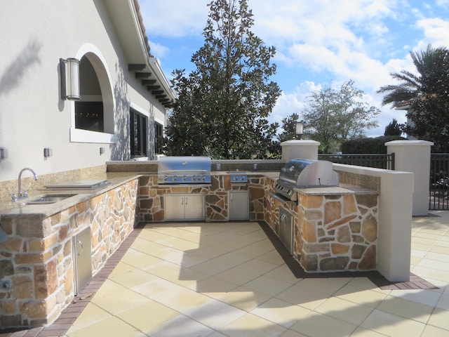 view of patio with an outdoor kitchen, area for grilling, and sink