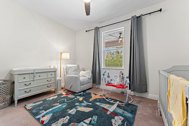 bedroom featuring ceiling fan, carpet floors, and a crib