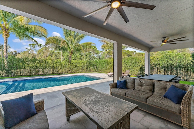 view of swimming pool with ceiling fan, a patio area, and an outdoor living space