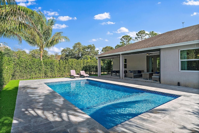 view of pool featuring an outdoor living space, a patio, and ceiling fan