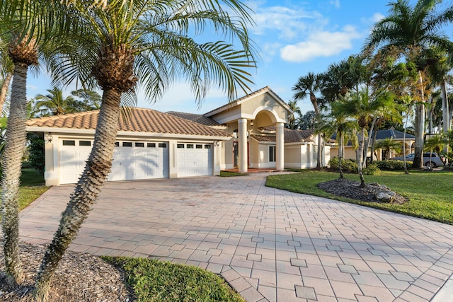 mediterranean / spanish house with a front yard and a garage