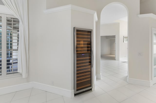 interior space with bar, wine cooler, and crown molding