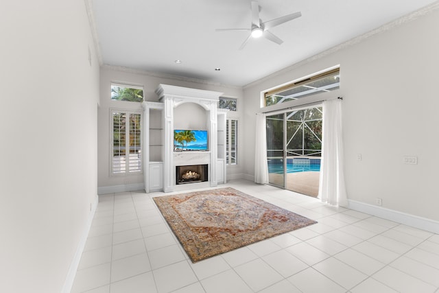 tiled living room featuring ceiling fan, ornamental molding, and a high ceiling