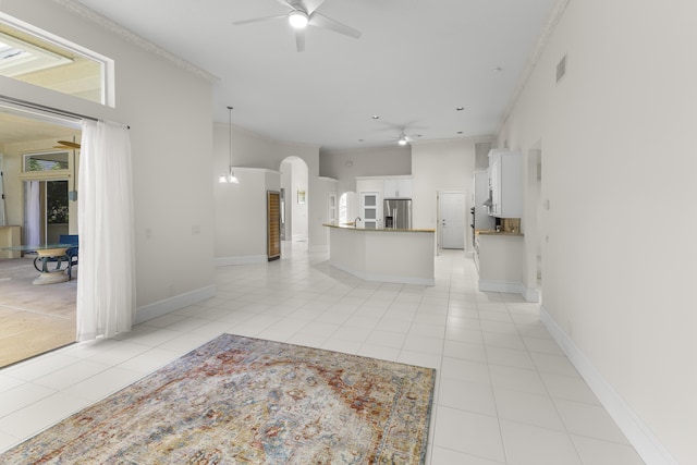 kitchen featuring stainless steel refrigerator with ice dispenser, a towering ceiling, white cabinetry, and light tile patterned floors