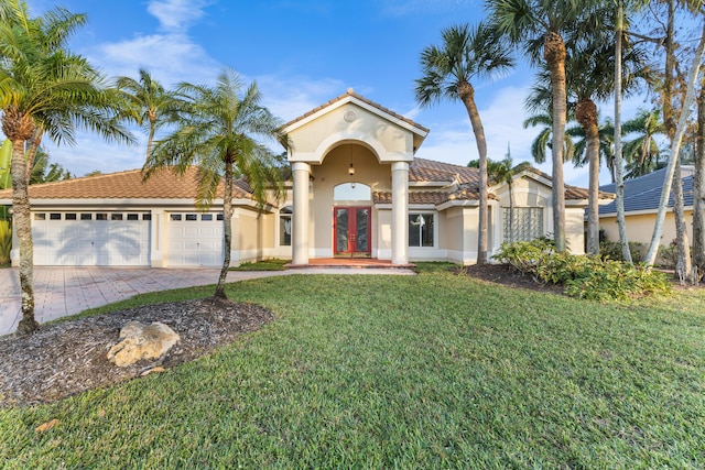 mediterranean / spanish house featuring french doors, a front yard, and a garage