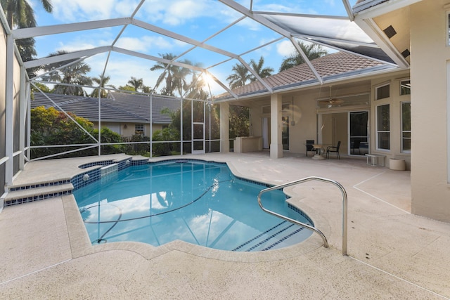 view of pool featuring a patio area, ceiling fan, an in ground hot tub, and glass enclosure