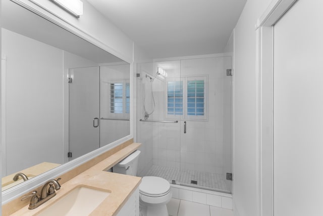 bathroom with toilet, tile patterned flooring, a shower with door, and vanity