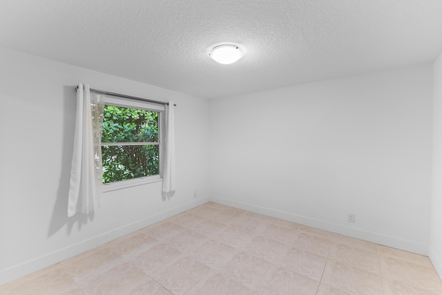 tiled spare room with a textured ceiling