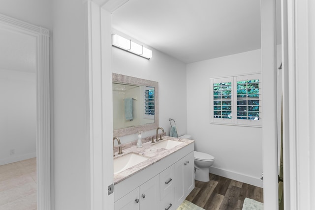 bathroom with toilet, hardwood / wood-style floors, and vanity