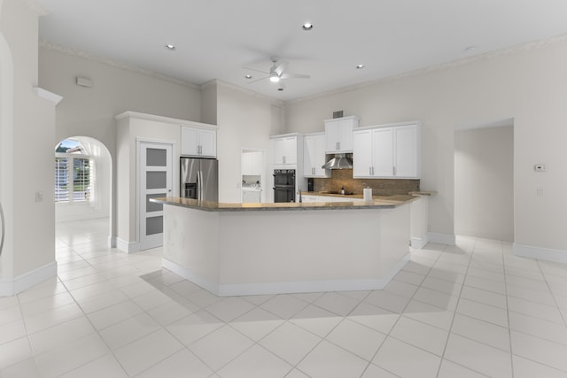 kitchen with white cabinets, ceiling fan, backsplash, and stainless steel refrigerator with ice dispenser