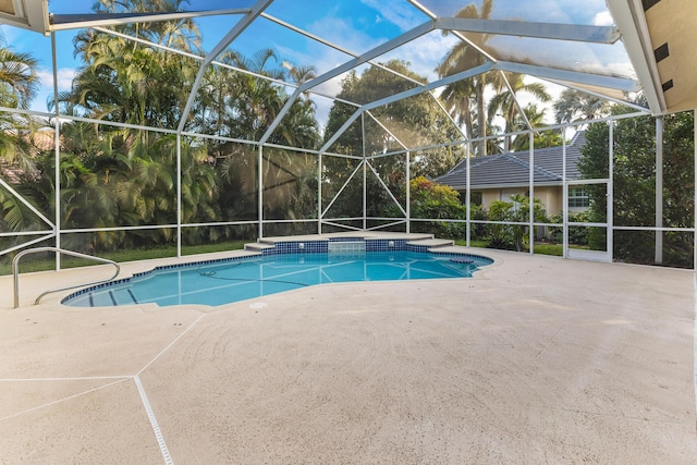 view of pool with a patio area and glass enclosure