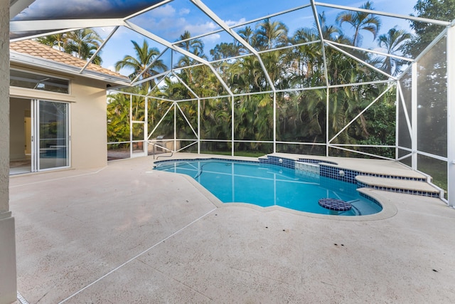 view of pool with a lanai, a patio, and an in ground hot tub