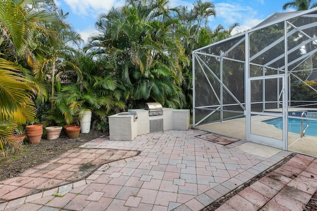 view of patio / terrace with exterior kitchen, a lanai, and a grill