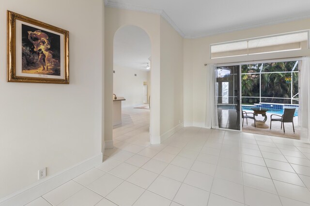 tiled spare room with ceiling fan and crown molding