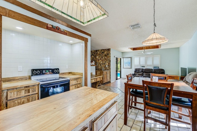 kitchen with range with electric cooktop, ceiling fan, hanging light fixtures, wooden counters, and light tile patterned floors