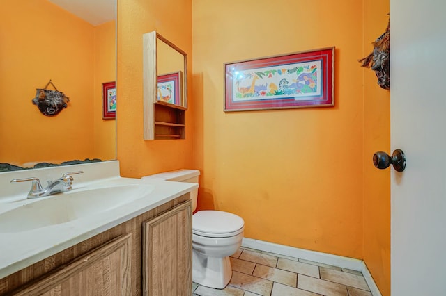 bathroom featuring tile patterned flooring, vanity, and toilet