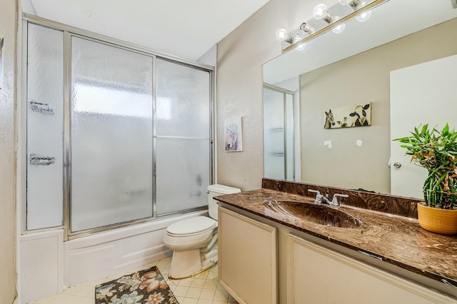 full bathroom with tile patterned flooring, vanity, bath / shower combo with glass door, and toilet