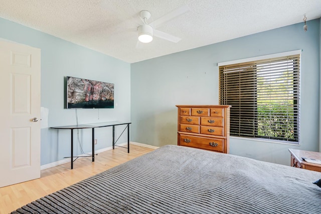 bedroom featuring a textured ceiling, light hardwood / wood-style flooring, and ceiling fan